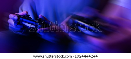 gamers playing console video games. controller in hands closeup. neon lights banner