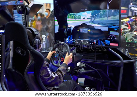 Gamers are playing racing games on a car simulator with a steering wheel background. race drive simulator