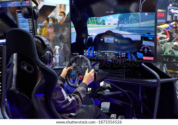 Gamers are playing\
racing games on a car simulator with a steering wheel background.\
race drive simulator