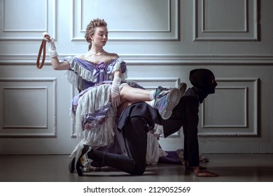 Games. Cinematic Portrait Of Young Adorable Woman In Image Of Medieval Royal Person In Evening Dress With Servant Isolated On Vintage Background. Comparison Of Eras, Beauty, History, Art, Creativity.