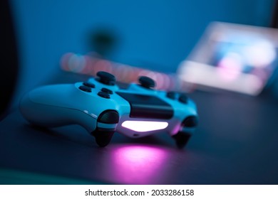 Gaming Controller Laying On Table. Close-up Of Gamepad In Low Light Room. Selective Focus. Professional Computer Game Playing, Esport Business And Online World Concept.