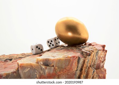 Gaming Dice With Gold Nest Egg On Rock Combine Into Symbolic Warning To Avoid Financial Risk To An Investment Nest Egg