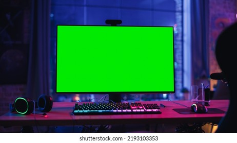 Gaming at Home: Empty Gamer Station with Player's Personal Computer with Green Screen Chroma Key Display Standing on a Wooden Desk in Cozy Loft Apartment with Neon Lights. - Shutterstock ID 2193103353