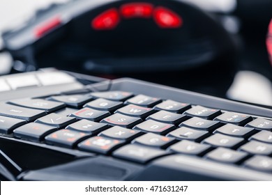 A Gaming Keyboard, Mouse And Headset Shot Over A Dark Reflective Surface