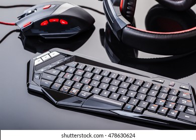 eine Gaming-Tastatur, -Maus und ein Headset auf einer dunklen, reflektierenden Oberfläche