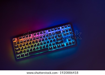 Gaming keyboard with RGB light. White mechanical keyboard. Gamer's workspace, neon light
