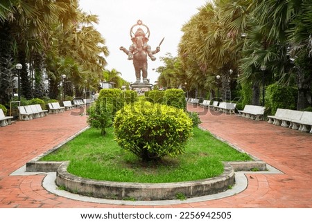 Ganesh or Ganesha bronze statue, The Lord of Success  that  standing statue enshrined in the gardening park with tree on row  in Hinduism temple, Chachoengsao ,Thailand 