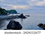 Gangneung City, South Korea - July 29th, 2019: The tranquil Heonhwa Road, with rocks set in calm waters under a blue sky, offers a stunning backdrop to the serene Simgok Port.