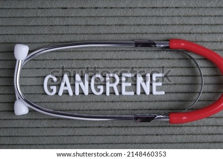 gangrene - text from white letters on  green background with  stethoscope, medical concept diagnostics, treatment.