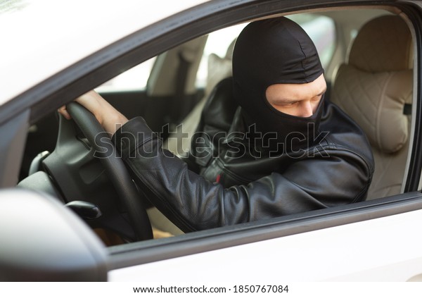 gangster in a\
black mask steals someone else\'s\
car