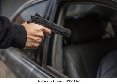 gangster, criminal, Bad man Kill victim in Car,Murder concept,Hands of Points Gun at Suspicious Car Passenger.,Terrorist or a car thief pointing a gun at the driver - car owner.