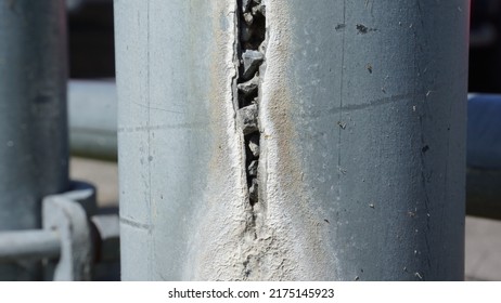 Gap, Crack In Metal Cylinder Full Of Rubble. Cracked Metal Surface. Closeup On Grey Pillar, Pipe. - 14 June 2022, Montreal, Canada