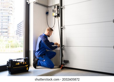 Garage Door Installation And Repair At Home. Contractor Man In House - Shutterstock ID 2032605872