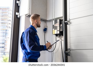 Garage Door Installation And Repair At Home. Contractor Man In House