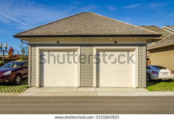 Garage\
door in luxury house with trees and nice\
landscape