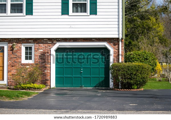 Garage Door Painted in Green Color for  one car in a\
single American House 