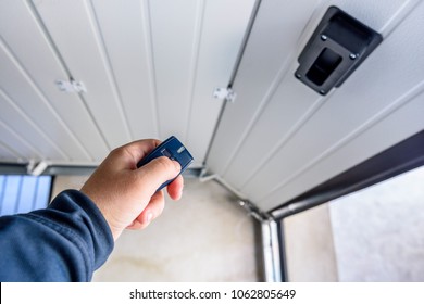 Garage door PVC. Hand use remote controller for closing and opening garage door. - Shutterstock ID 1062805649