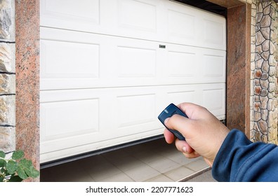 Garage door PVC. Hand use remote controller for closing and opening garage door - Shutterstock ID 2207771623