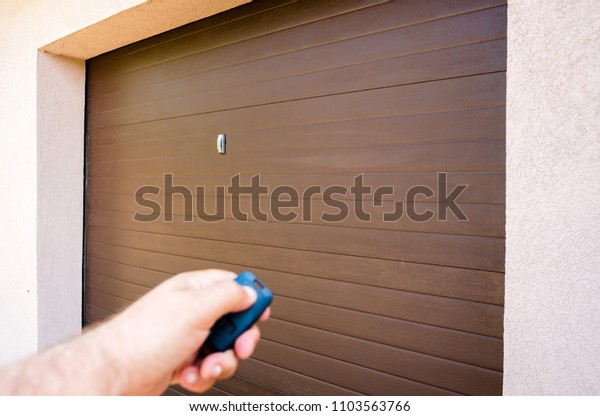 Garage door PVC. Hand use remote controller for\
closing and opening garage\
door.