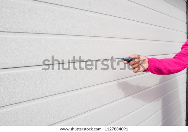 Garage door PVC. Hand use remote controller for\
closing and opening garage\
door