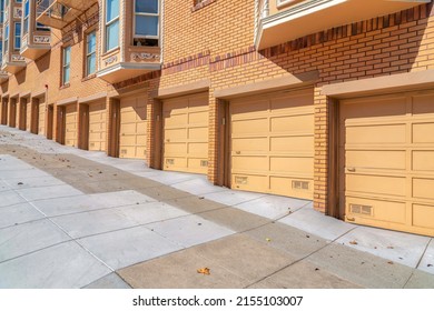 Garage doors of an apartment building with yellow orange brick walls exterior in San Francisco, CA