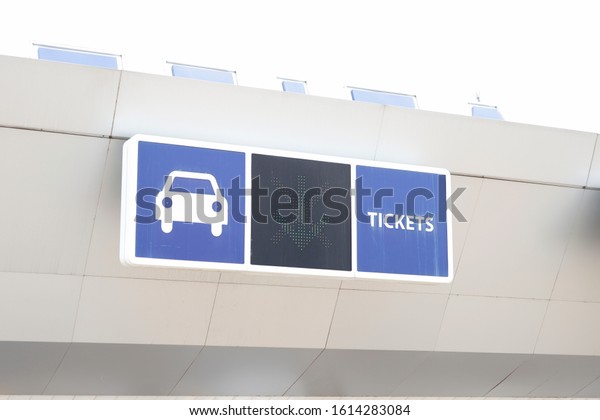 Garage entrance with a car and tickets sign in\
blue background