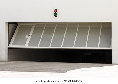 Garage Gate Or Door Opening To Underground Car Parking. Modern Automatic Garage Gate With Entrance Door And Lamp Indicator 