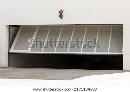 Garage Gate or Door Opening to Underground Car Parking. Modern Automatic Garage Gate with Entrance Door and Lamp Indicator 
