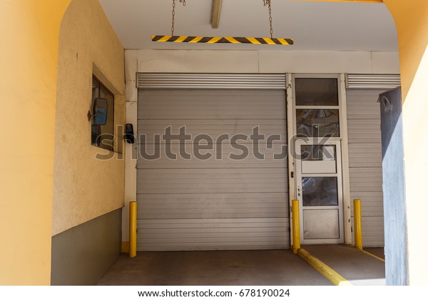 Garage lift gates in yellow house,\
gates of parking for cars in residential\
building