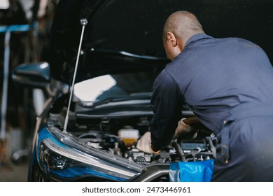 Garage Mechanic African Black male professional working car auto service checking engine oil at front hood. - Powered by Shutterstock