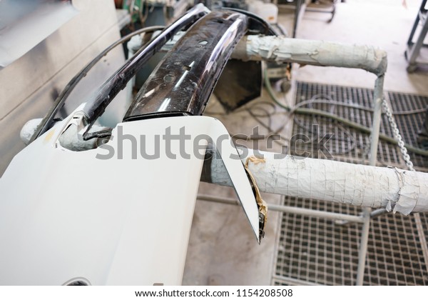 Garage painting car\
service. bumper section of the car is covered with primer.\
Repairing car body work after the accident by working sanding\
primer before painting.