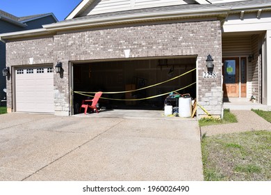 A Garage With Police Tape Across It. The House Is Beige. Picture Taken In St. Peters, Missouri On March 27th, 2021.