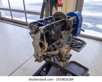 in a garage there is an opened engine block of a car