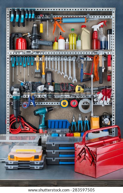Garage tool rack with various tools and repair\
supplies on board and\
shelves.
