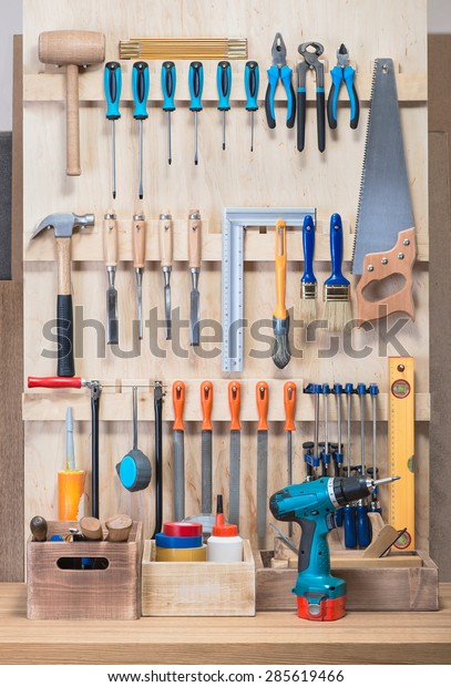 Garage tool rack with various tools and repair\
supplies on board and\
shelves.