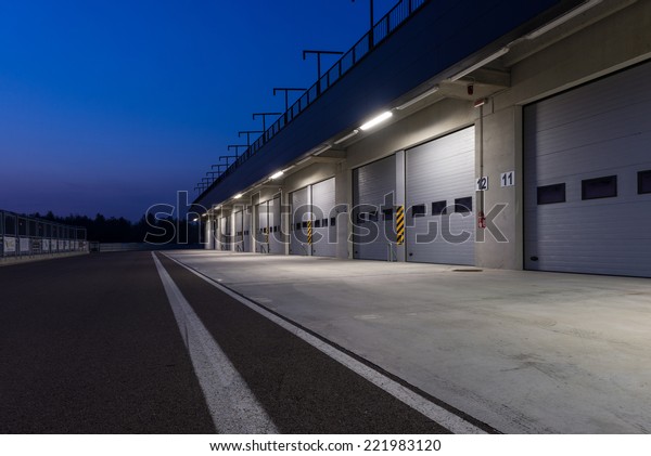 Garages in race circuit.\
Night time.