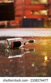 Garbage After Party In The Street Concept. Empty Alcohol Bottle On The Floor At Campus During Sunset