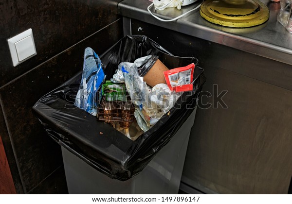 Garbage bin filled with garbage in the\
restaurant\'s kitchen