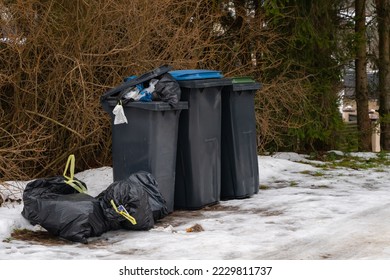 Garbage bin full of trash on white snow in residential area in winter. - Powered by Shutterstock