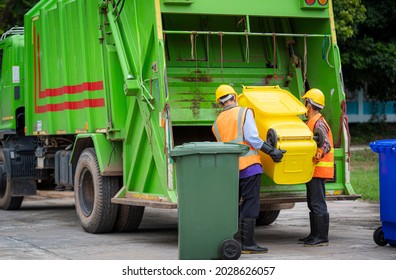 Garbage collection service,Rubbish cleaner man in a uniform working together on emptying dustbins for trash removal with truck loading waste and trash bin,Recycling concept.