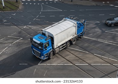 Garbage collection truck driving through the city with municipal waste - Shutterstock ID 2313264133