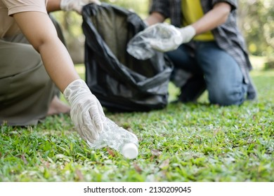 garbage collection, volunteer team pick up plastic bottles, put garbage in black garbage bags to clean up at parks, avoid pollution, be friendly to the environment and ecosystem. - Shutterstock ID 2130209045
