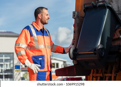 Garbage Collection Worker Putting Bin Into Waste Truck For Removal