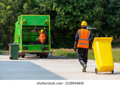 Garbage Collector, Garbage Man Working Together On Emptying Dustbins For Trash Removal.