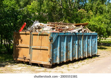 garbage container equipped for transportation by truck, filled with construction debris large iron container, construction waste.