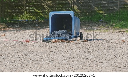 Garbage Container Tipped Over by Strong Wind or Vandals on Outdoor Public Parking Lot 