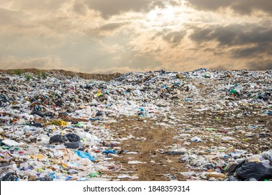 garbage dump pile in trash dump or landfill,backhoe and truck is dumping the gabage from municipal,garbage dump pile and dark sky background  ,pollution concept - Shutterstock ID 1848359314