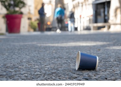 Garbage, empty cup of coffee left in the middle of the street contributing to pollution. 