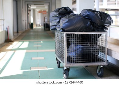 Garbage and the full of trash bag in cart trolley at hallway building.