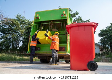 Garbage Man Working Together On Emptying Dustbins For Trash Removal.